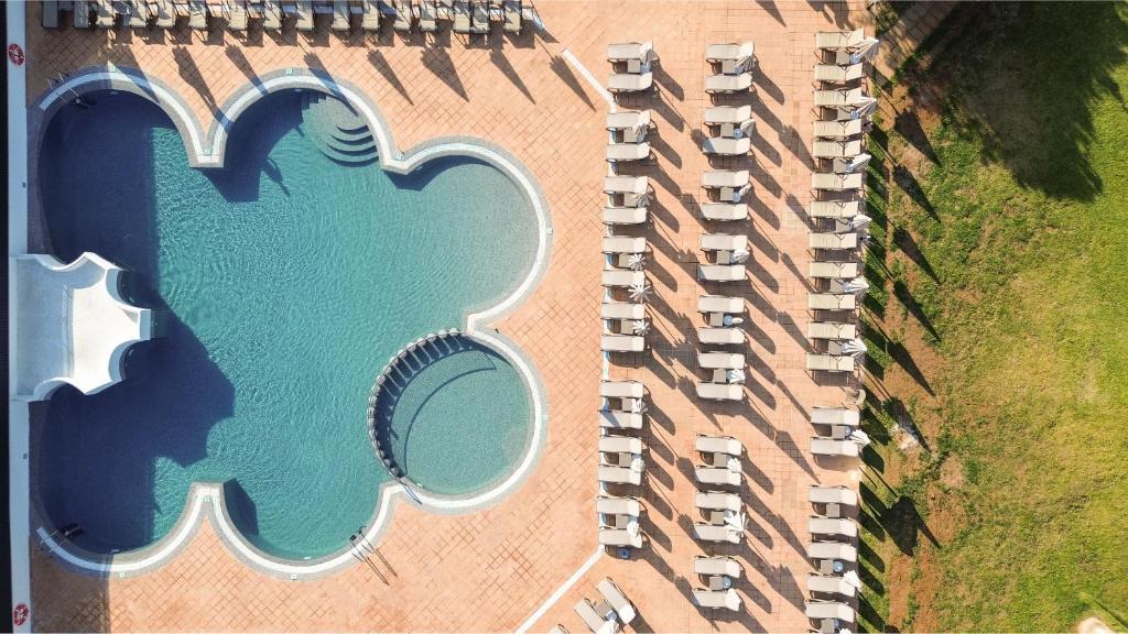 サ・コマにあるHotel Caprice Sa Coma Parkの大きなプールのある建物の上空からの眺め