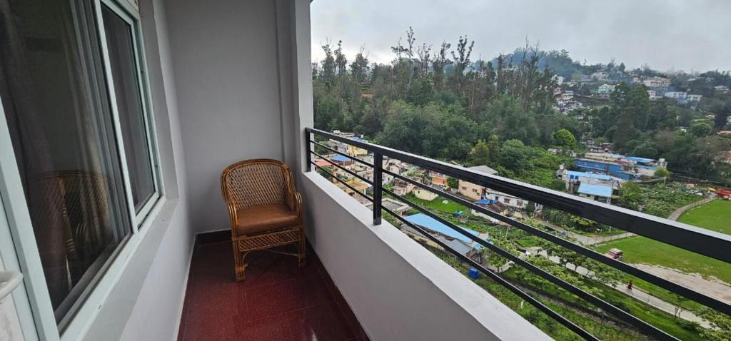 a balcony with a chair and a view of a city at hotel ruby international in Kodaikānāl