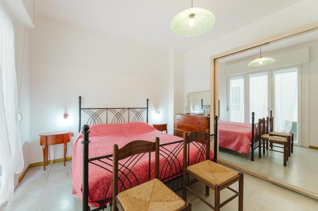 a bedroom with a red bed and a mirror at Anna Flat - 2 minuti dalla spiaggia in Lido di Jesolo