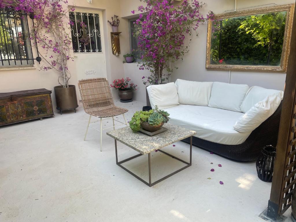 a living room with a white couch and a table at the garden house in Dhaskalión