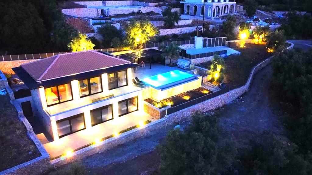 an aerial view of a house at night with a swimming pool at Carmelia Villas in Agios Nikitas