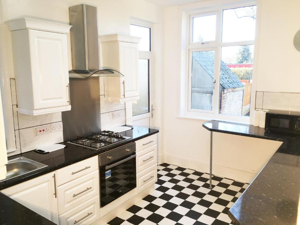 una cucina con pavimento a scacchi in bianco e nero di Park Drive TownHouse a Manchester