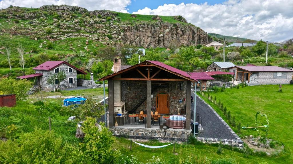a small house in a field with a hill in the background at River Home in Kʼaghsi
