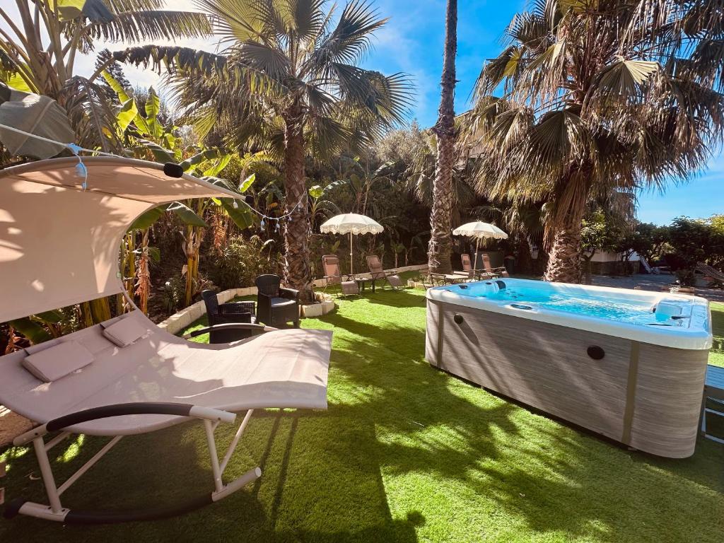a pool with a chair and an umbrella in a yard at Villa Tiche in Cefalù