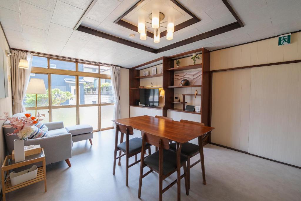 a dining room with a table and a couch at Tiger House Kusabana in Akiruno