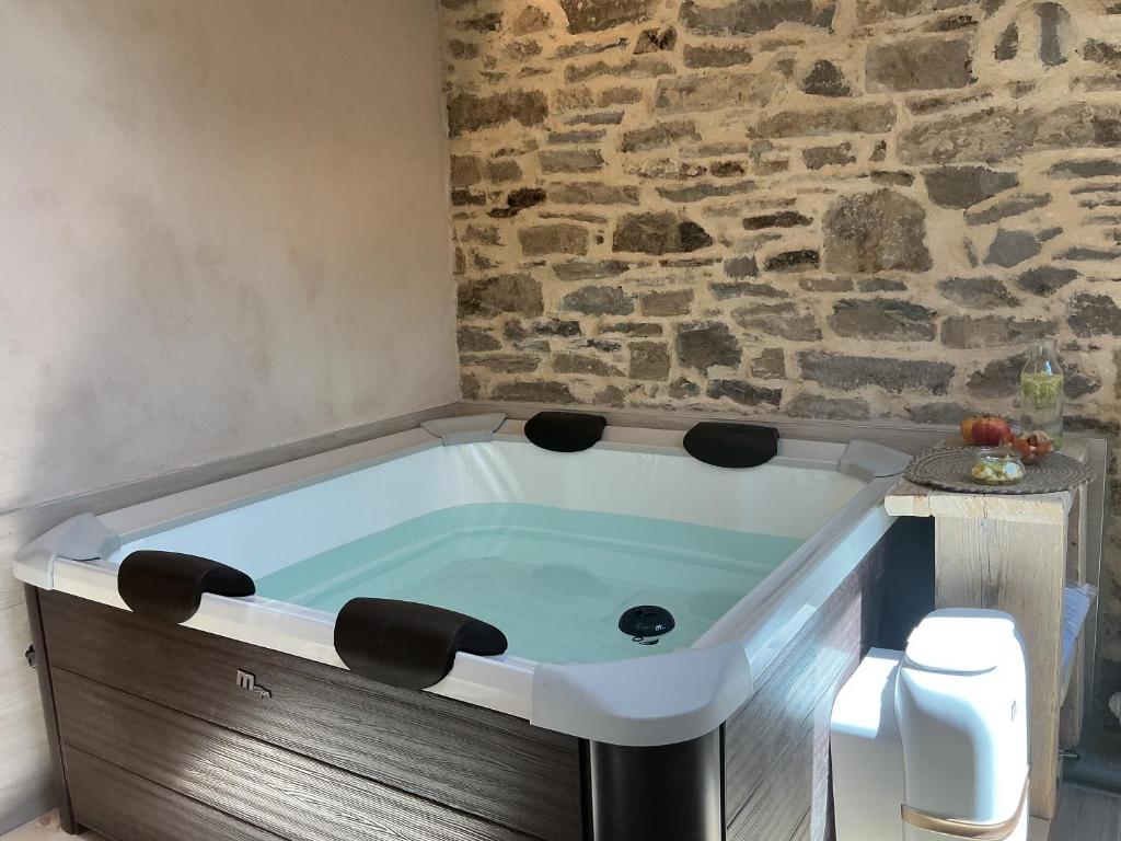 eine Badewanne in einem Badezimmer mit einer Steinwand in der Unterkunft Borgo Poli in Fanano