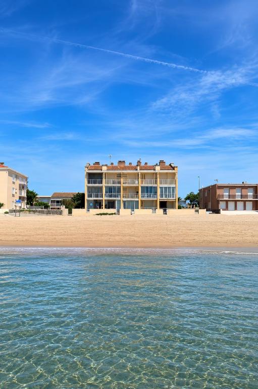 a building on the beach next to the water at Studio rénové à Palavas avec accès direct à la plage in Palavas-les-Flots