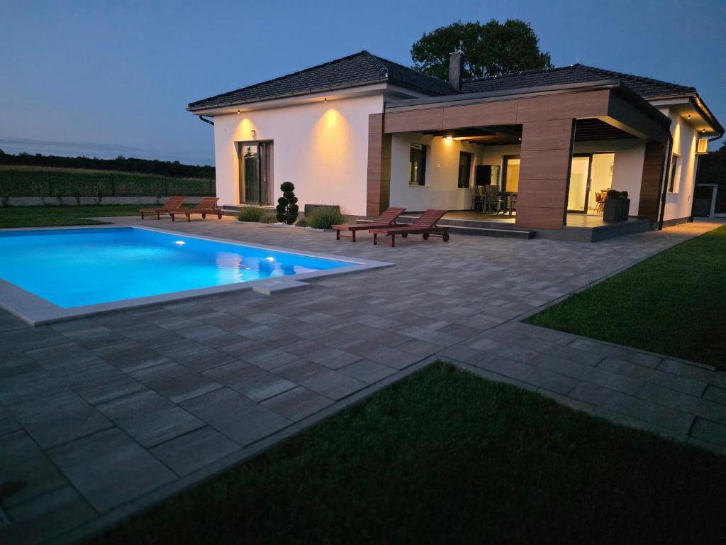 a villa with a swimming pool in front of a house at Blackberry Guesthouse in Jastrebarsko