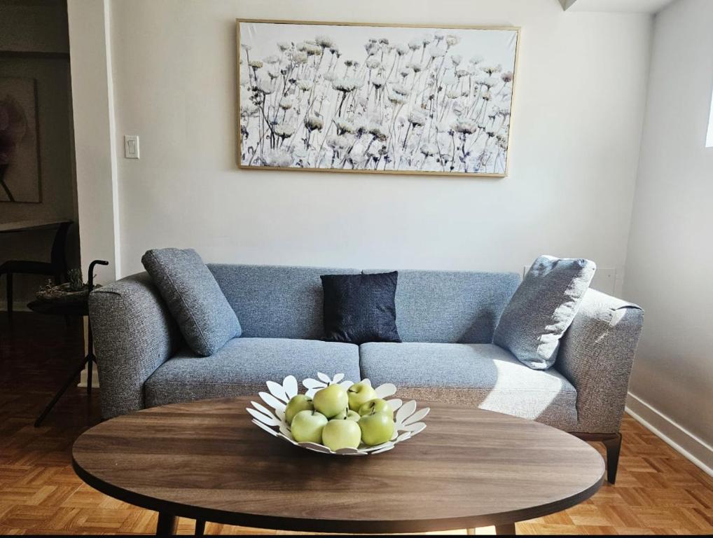 a living room with a couch and a table with a bowl of fruit at Where Comfort Meets Cozy Vibes in Montreal