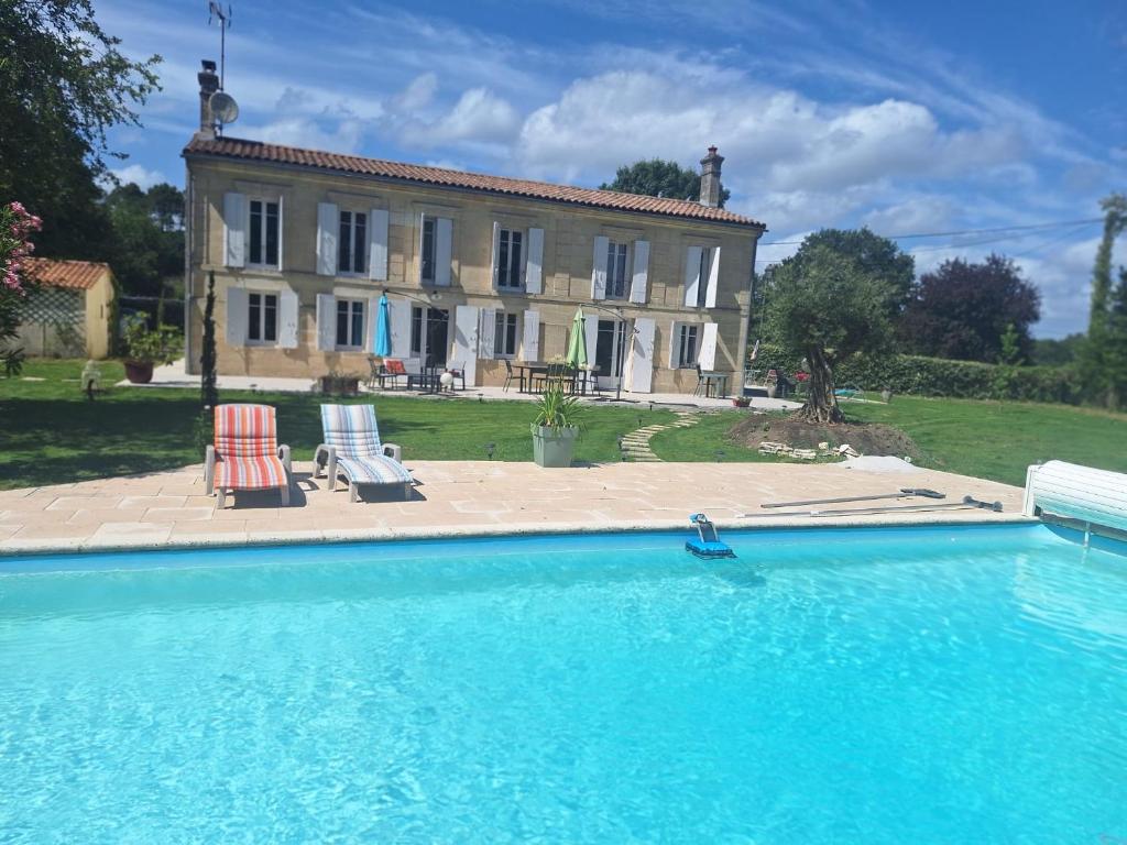 a large house with a swimming pool in front of it at Calme et quiétude in Saint-Vivien-de-Blaye