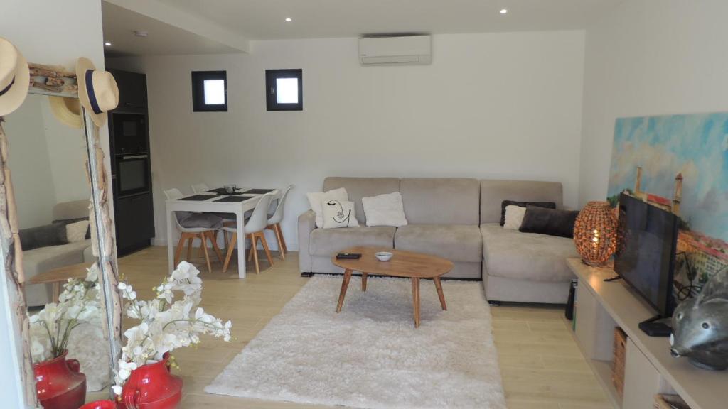 a living room with a couch and a table at Villa Studio Cosy Hauteur Vallauris L'Atelier in Vallauris