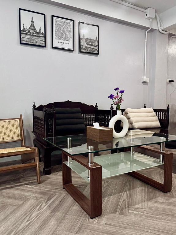 a living room with a glass table and a couch at Soulstay Bangkok in Bangkok