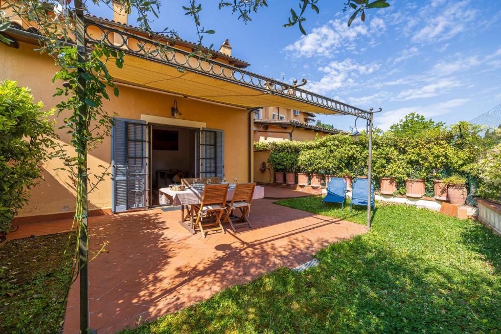 a patio with a table and chairs in a yard at Aiuola133 in Cetona
