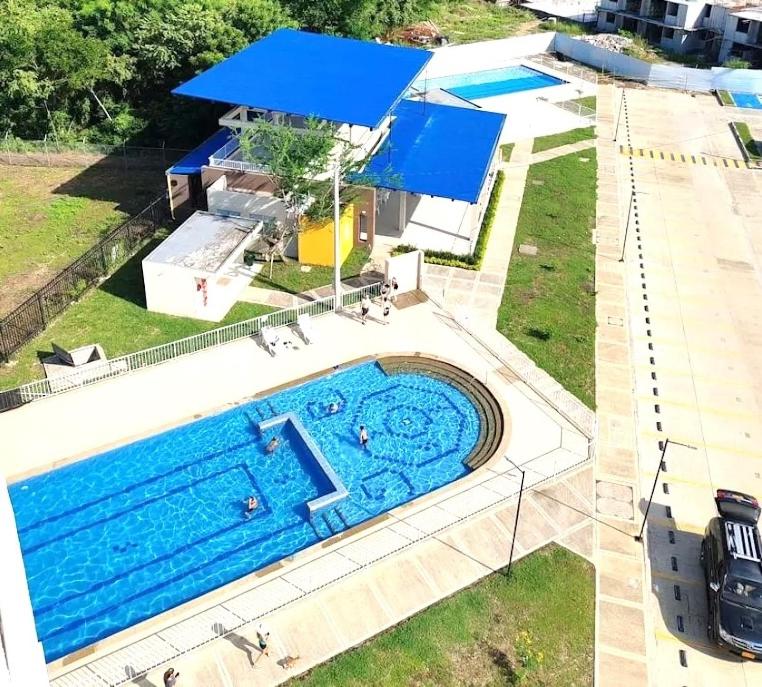 an overhead view of a swimming pool with a blue umbrella at Five Homes Ricaurte in Ricaurte