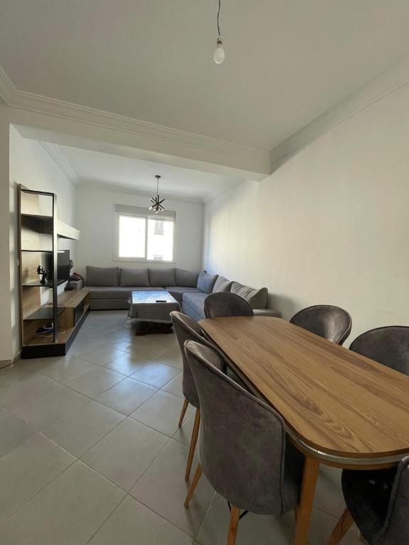 a living room with a table and a couch at Complex riad tanger in Hajreien