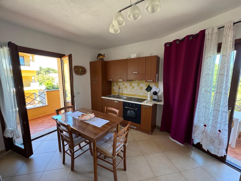a kitchen with a wooden table and a dining room at Carpa House in Valledoria