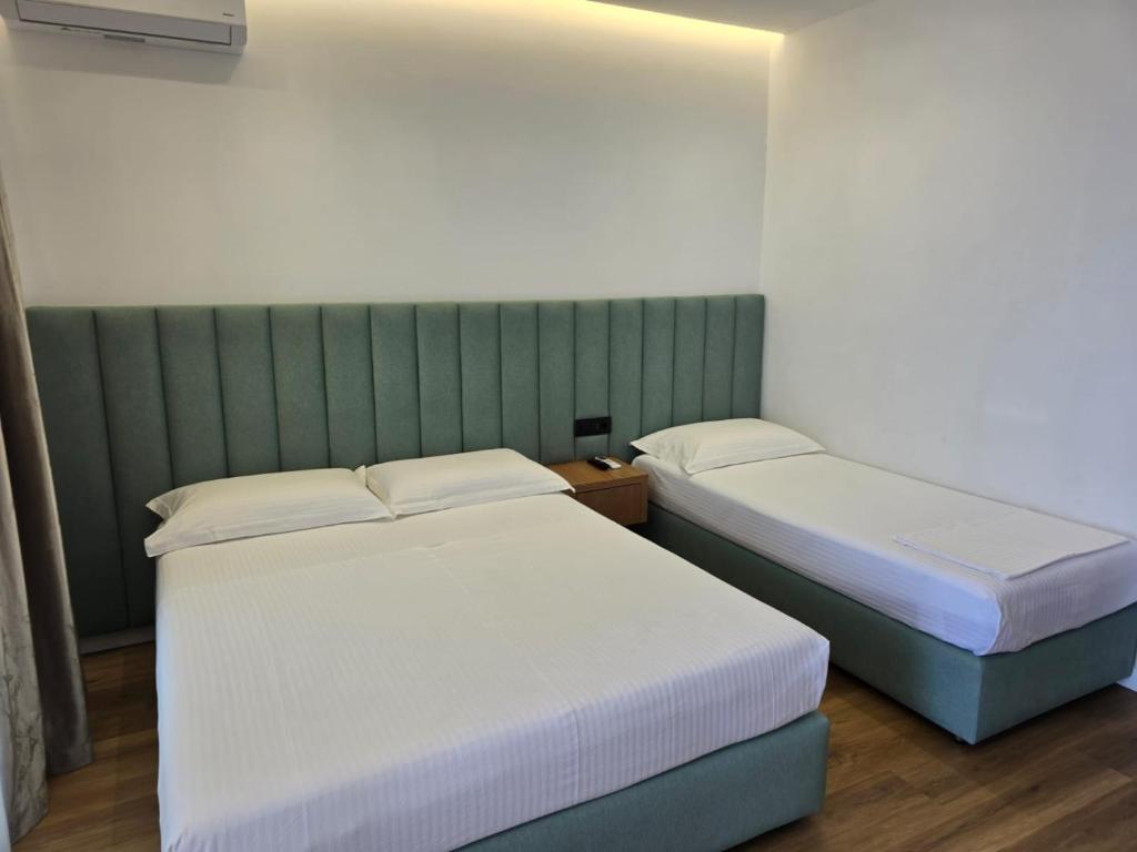 two beds sitting next to each other in a room at Rei Hotel in Borsh