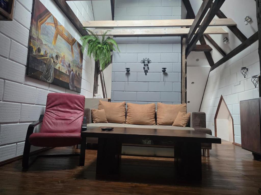 a living room with a couch and a red chair at Duplex U Marzeny in Ostróda