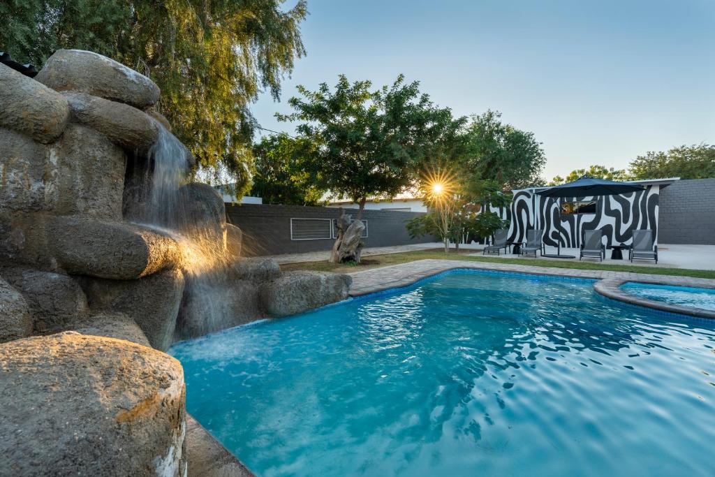 ein Swimmingpool mit Wasserfall im Garten in der Unterkunft DIE Stoep in Uis