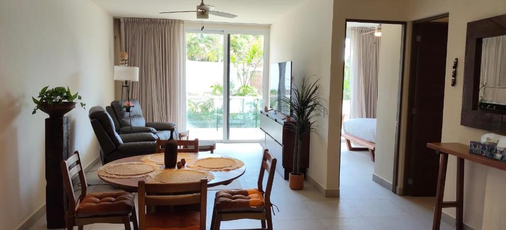 a living room with a table and chairs in a room at Akumalito Santamar in Akumal