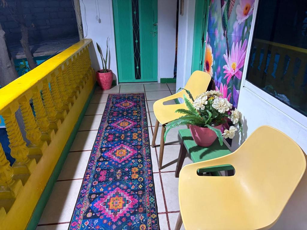 a balcony with yellow chairs and a rug on the floor at Playa Zen Rodadero in Rodadero