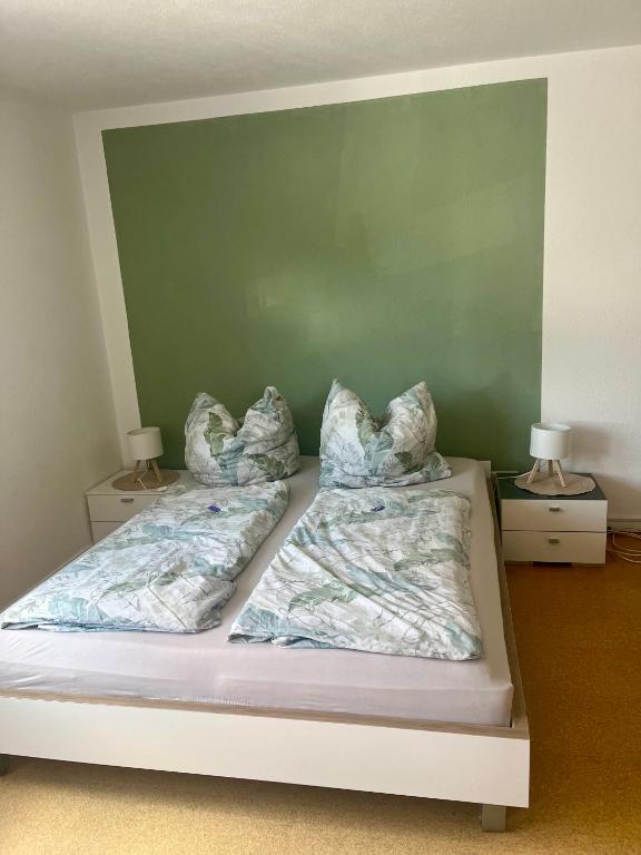 a bed with two sheets and pillows on it at Ferienwohnung Nähe Autobahn Ruhige Lage für Familien & Monteure in Erolzheim