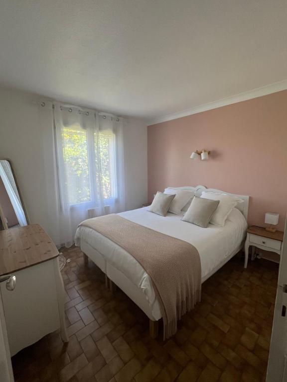 a bedroom with a large white bed and a window at La Maison d'Orange - Au calme à 2 pas du Théâtre Antique in Orange