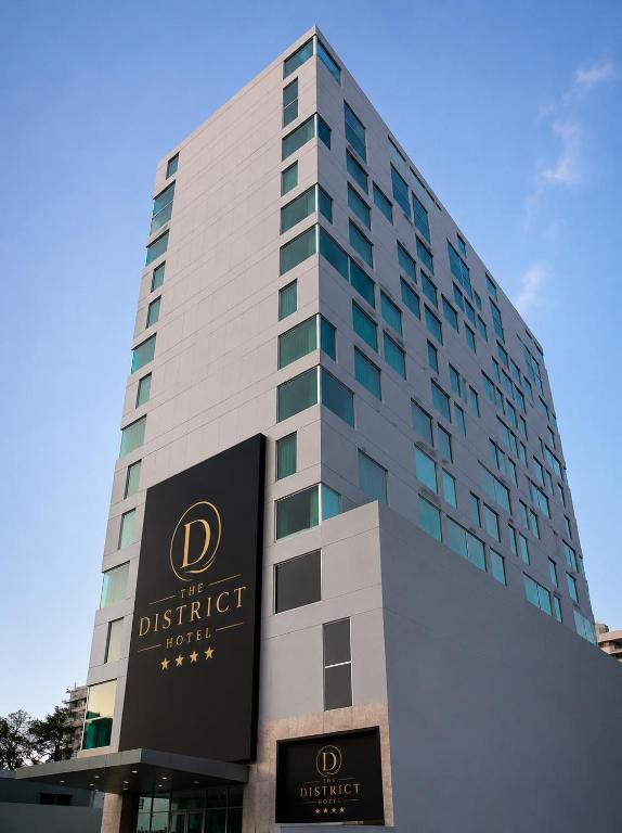 a tall building with a sign in front of it at The District Hotel in Panama City