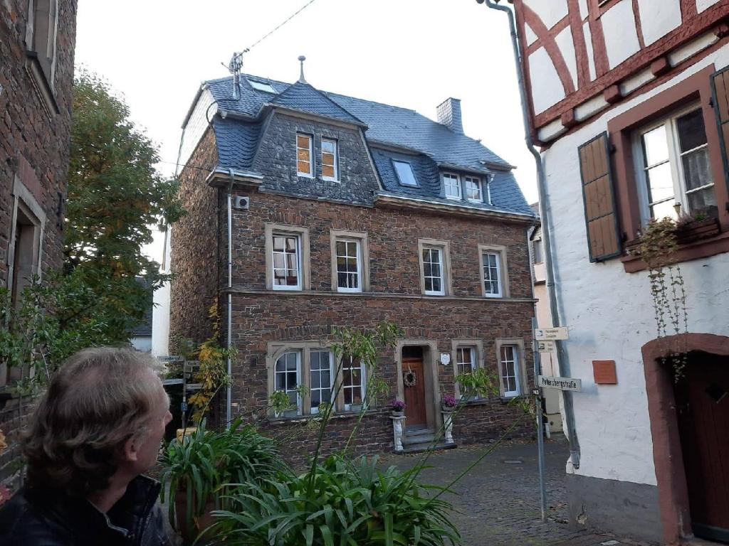 a man standing in front of a brick house at Wunderschönes Winzerhaus Schenk in Neef