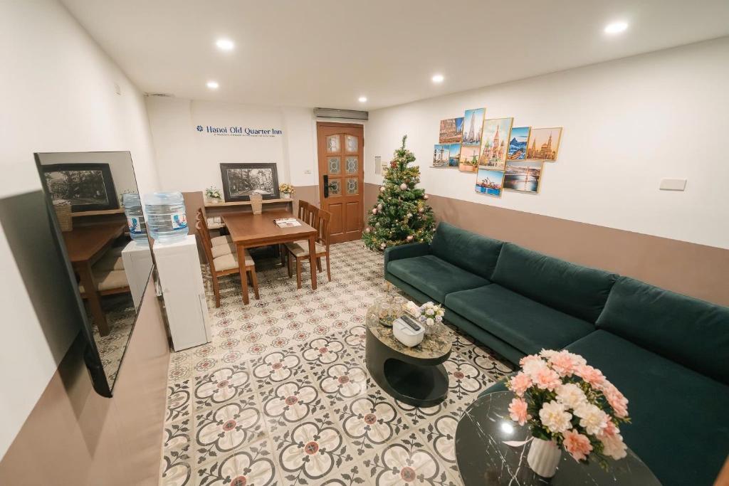 a living room with a green couch and a christmas tree at Morden Apt 6Br Old Quater in Hanoi
