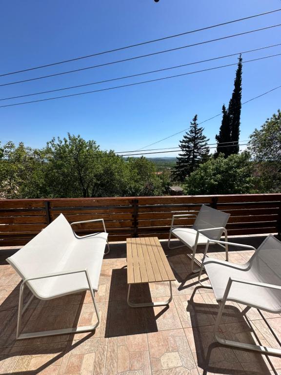 a group of white chairs and a table on a patio at Száka Kőház in Balatonfüred