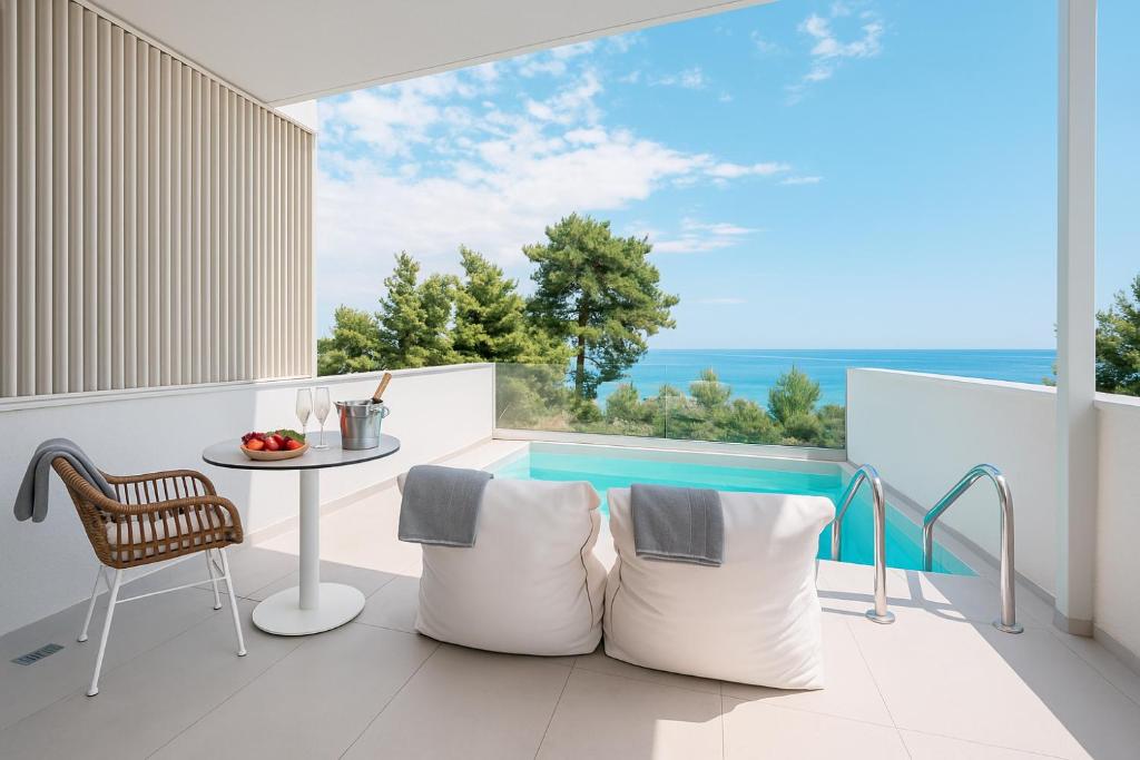 a balcony with a table and a view of the ocean at Gloria Luxury Suites in Kallithea Halkidikis