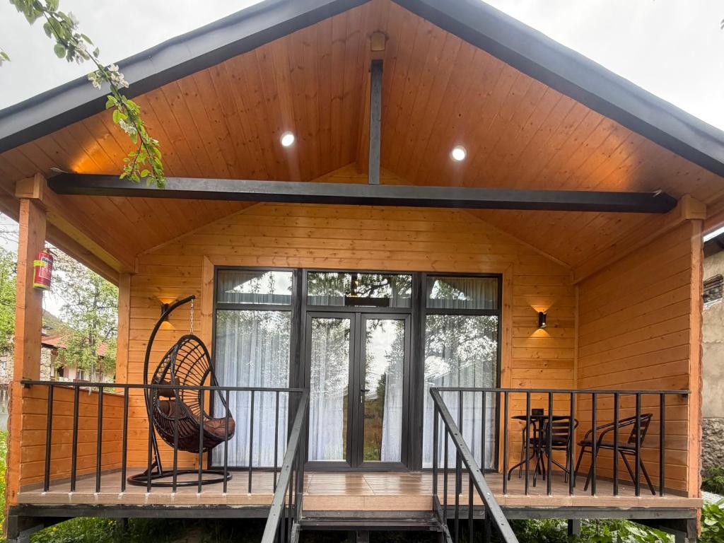a home with a large glass door and a porch at Cottage Ametapi in Mestia