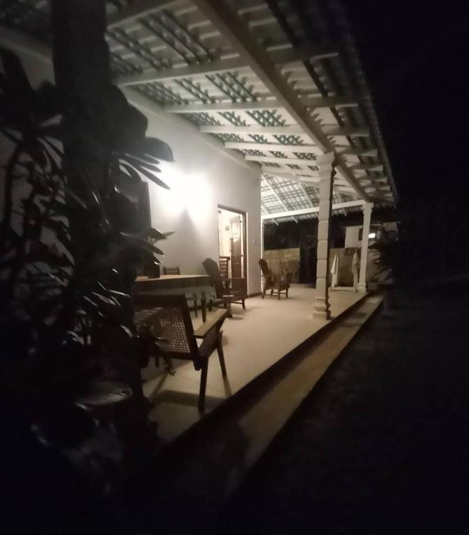 a living room with chairs and a table in a building at Amith Villa in Koggala