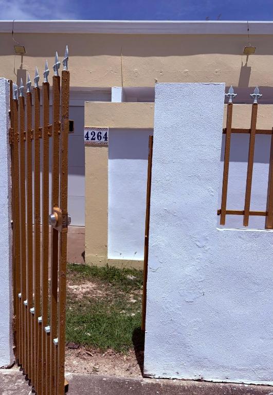 a fence in front of a building with the number at Comfortable Apartment in the Greater Ponce Area in Ponce