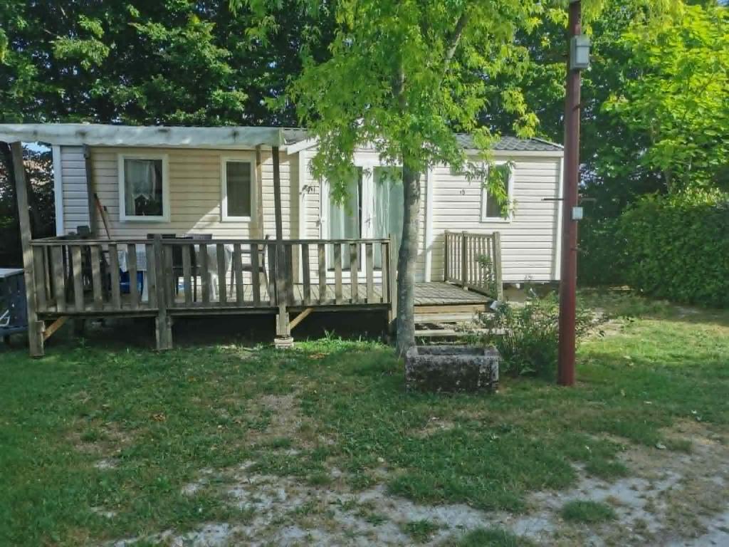 a tiny house with a porch and a deck at Camping du Pontis in Verteillac
