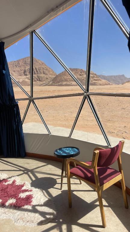 a room with a chair and a table in the desert at Tala Camp in Disah