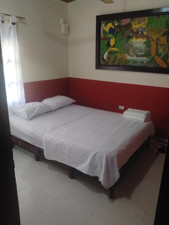 two beds in a room with a painting on the wall at Habitación Doble, Baño Privado, 4 Cuadras Del Rodadero, Zonas Comerciales in Gaira