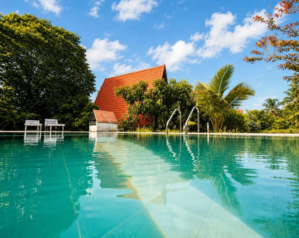 a swimming pool with a building in the background at Pahana village Sigiriya in Sigiriya