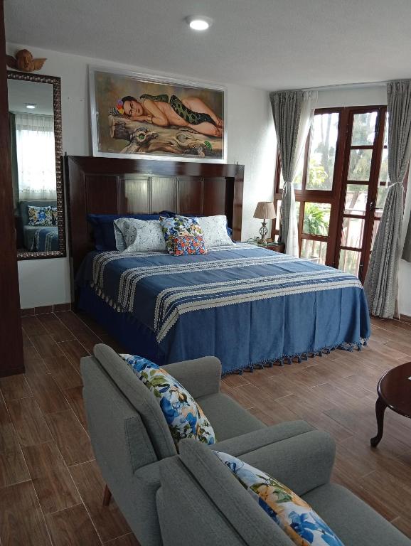 a bedroom with a bed and two chairs at Cómodo departamento en Xochimilco in Mexico City