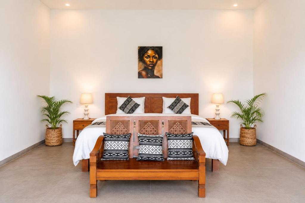 a bedroom with a bed and two plants at Bali Eco Retreat in Bangli
