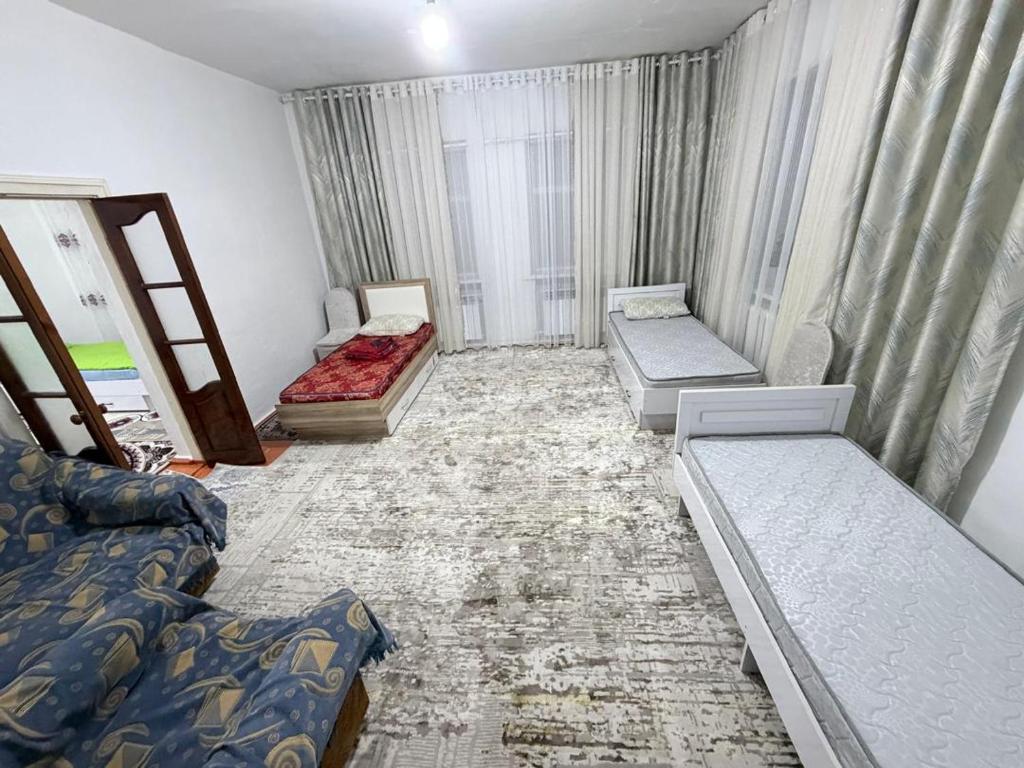 a room with three beds and a couch at Nur-Nomad in Balykchy