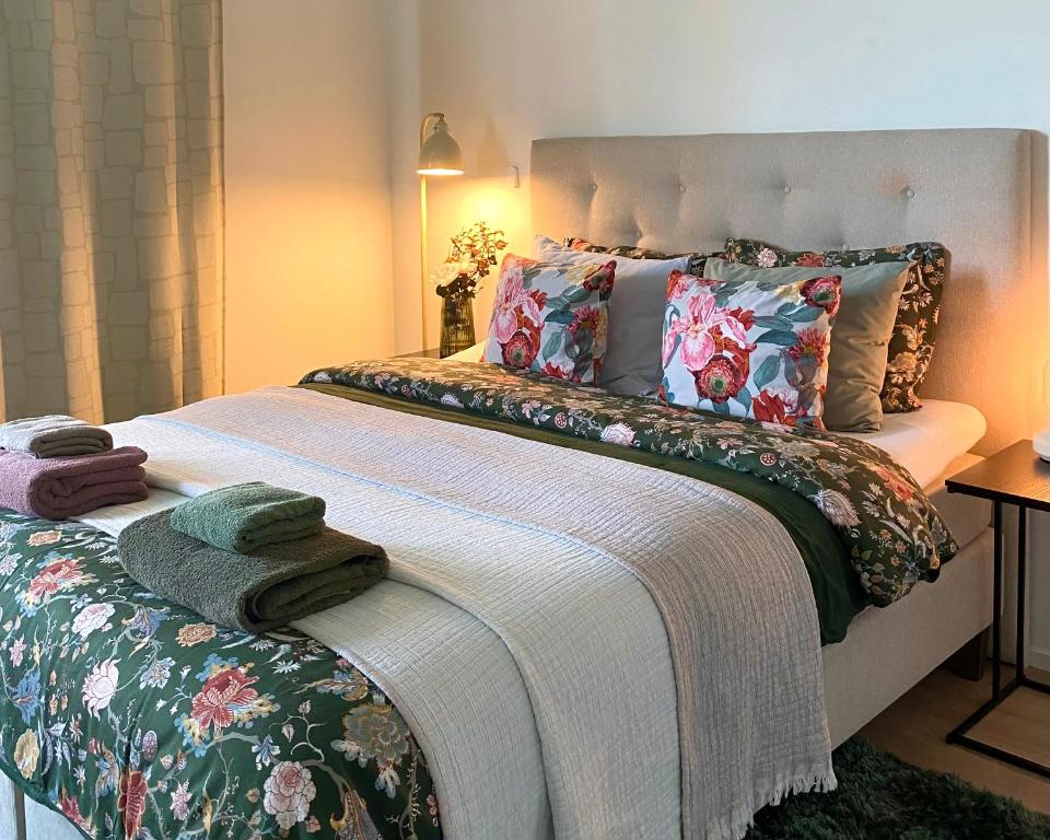 a bedroom with a large bed with floral pillows at One More Night in Jyväskylä