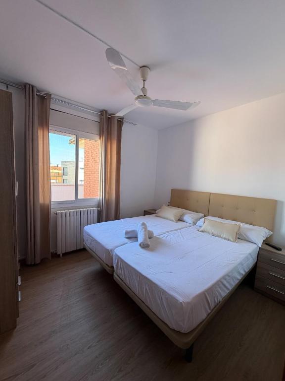 a bedroom with a large white bed with a window at Miramar Viladecans in Viladecáns