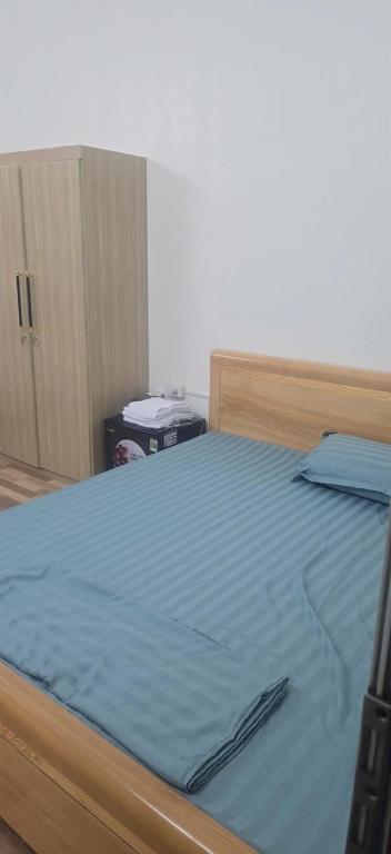 a bedroom with a bed with a blue comforter at Cô tô xinh in Quang Ninh