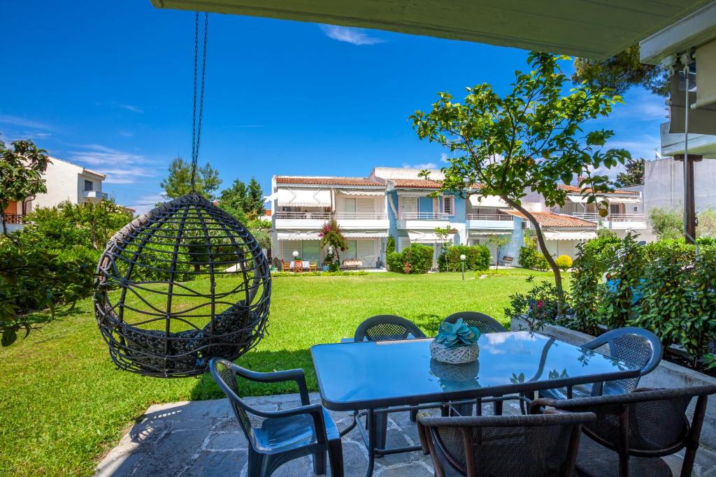 a patio with a blue table and chairs and a swing at Akrotiri apartment in Pefkochori