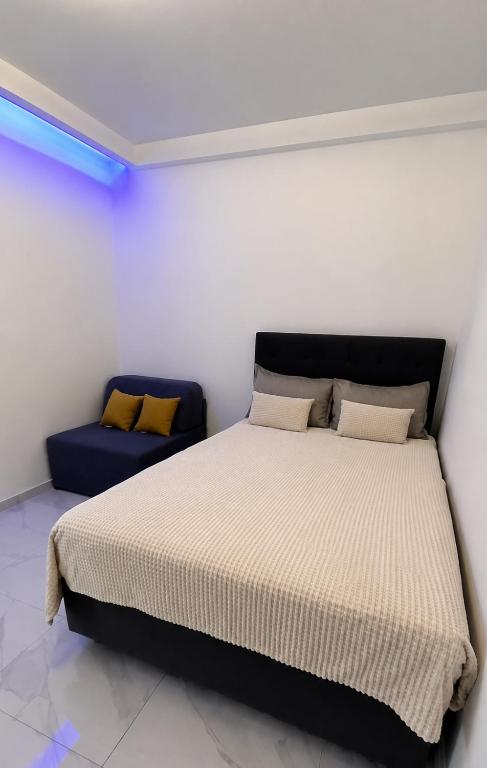 a bedroom with a bed and a blue couch at Aleksandra Delfini Apartments in Paralia Katerinis