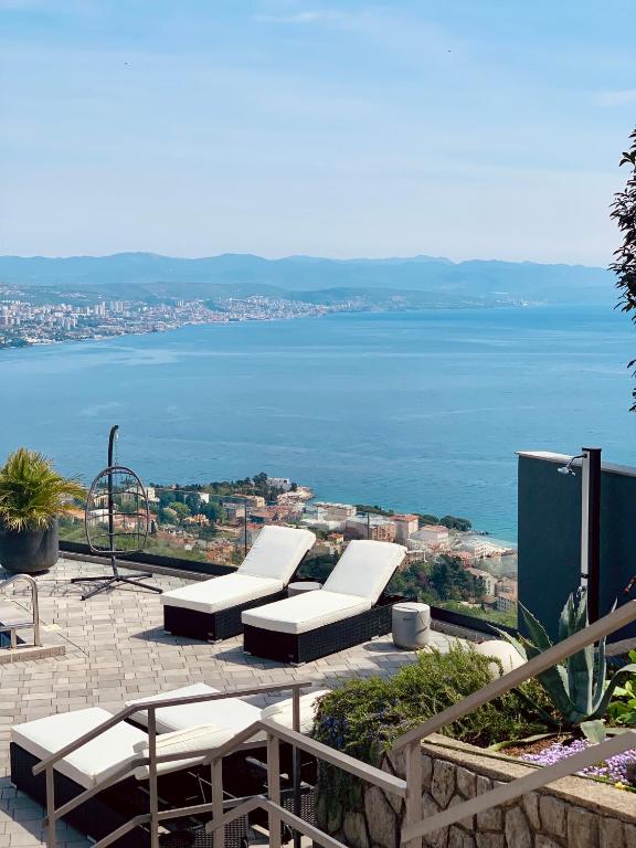 a group of white lounge chairs sitting on top of a building at Villa White Pearl Opatija Luxury Stay with Pool and Sea View in Opatija