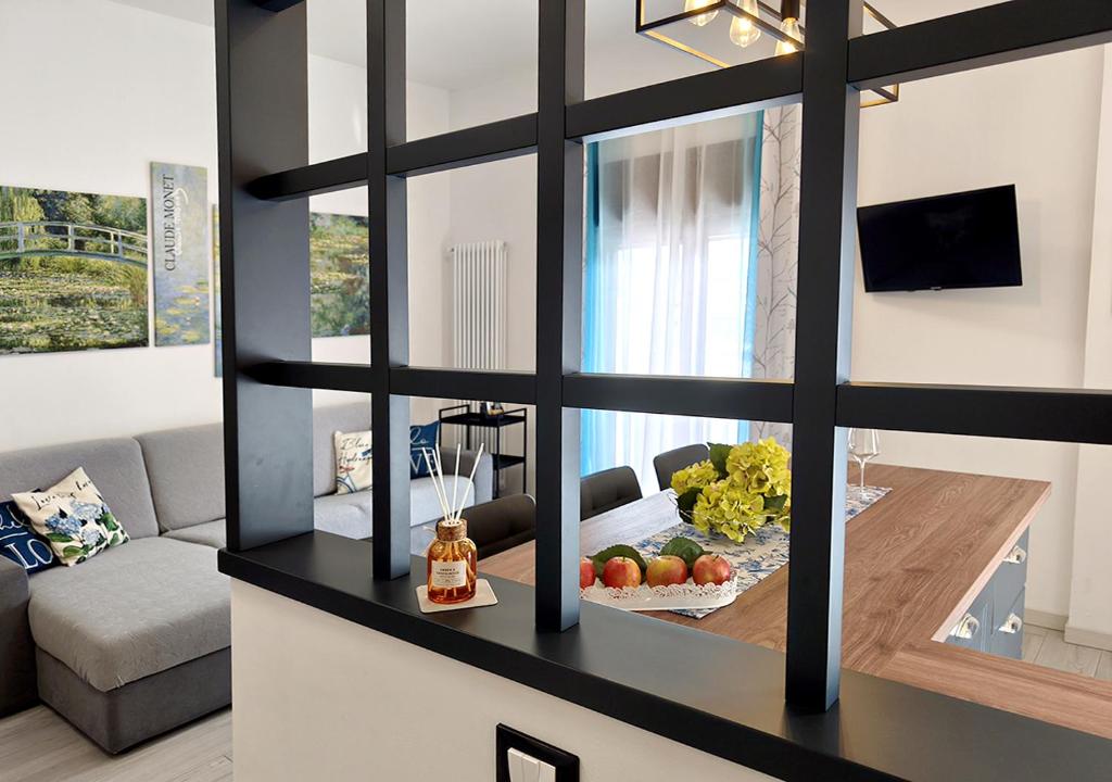 a living room with a table and a mirror at Vista lago Lecco - Neiade Guest house in Pescate
