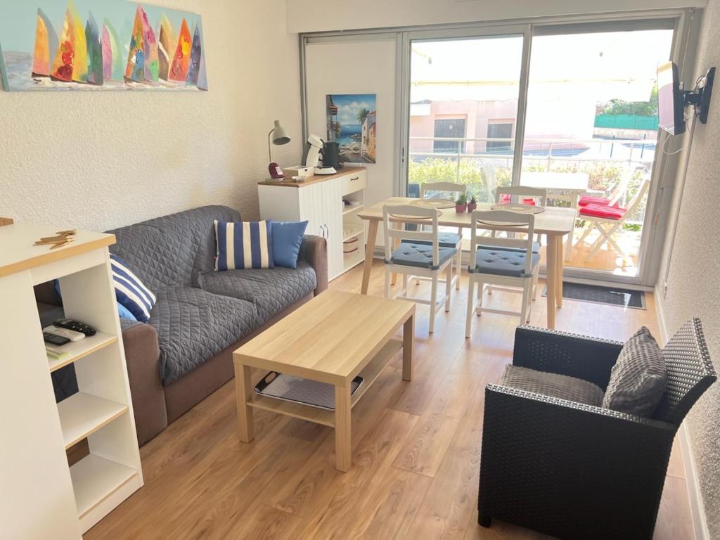 a living room with a couch and a table at appartement T2 climatisé proche centre et plage in Cavalaire-sur-Mer